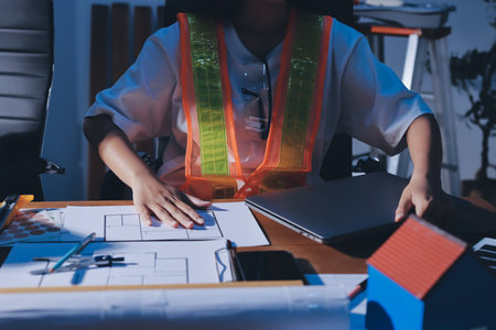 Closeup of team of industrial engineers meeting analyze machinery blueprints consult project on table in manufacturing factory. Working in manufacturing plant or production plant.の写真素材