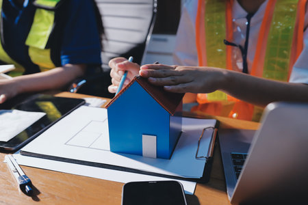 Closeup of team of industrial engineers meeting analyze machinery blueprints consult project on table in manufacturing factory. Working in manufacturing plant or production plant.の写真素材