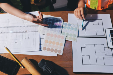 Closeup of team of industrial engineers meeting analyze machinery blueprints consult project on...