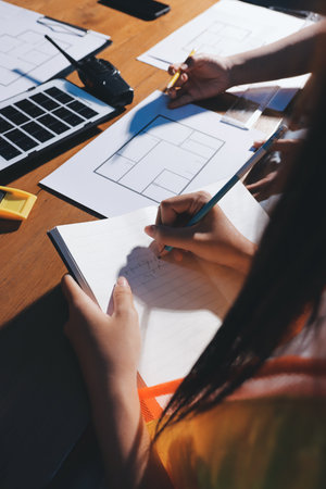 Closeup of team of engineers meeting analyze blueprints consult project on table. Working in plant or production plant.の写真素材