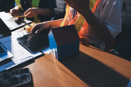 Closeup of team of industrial engineers meeting analyze machinery blueprints consult project on table in manufacturing factory. Working in manufacturing plant or production plant.の写真素材