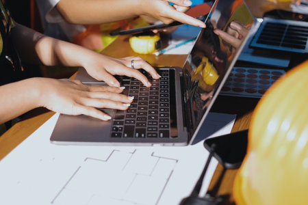 Closeup of team of industrial engineers meeting analyze machinery blueprints consult project on table in manufacturing factory. Working in manufacturing plant or production plant.の写真素材