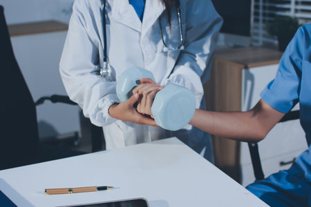 Person using hand weight with support of nurse