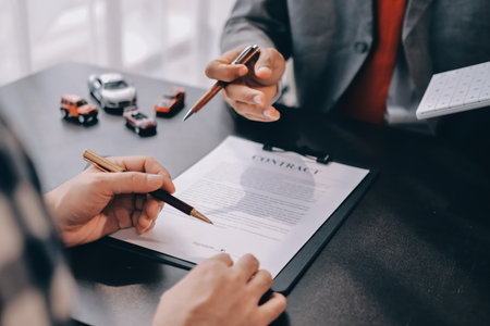 Car salesman gave the keys to the customers who signed the purchase contract legally, Successful completion of car sales, Purchase contract and key delivery.の写真素材