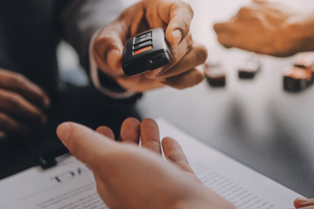Car salesman gave the keys to the customers who signed the purchase contract legally, Successful completion of car sales, Purchase contract and key delivery.の写真素材