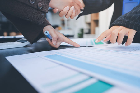 Business people shaking hands in office. Two business partners shaking hands after signing a...