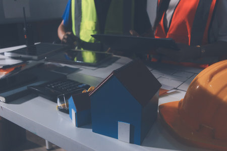 Closeup of team of industrial engineers meeting analyze machinery blueprints consult project on...