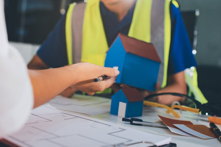 Closeup of team of industrial engineers meeting analyze machinery blueprints consult project on...
