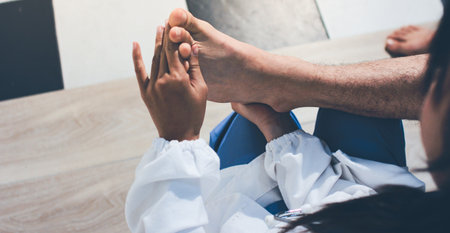 Physical therapist teaching a patient how to do exercises for his knee painの写真素材