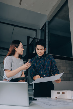 Construction manager and engineer explore construction documentation on the building site near the steel framesの写真素材