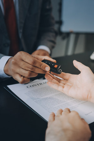 Car salesman gave the keys to the customers who signed the purchase contract legally, Successful completion of car sales, Purchase contract and key delivery.の写真素材