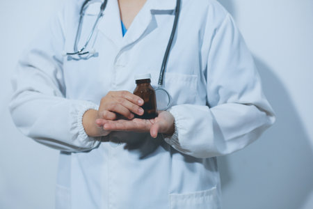 The pharmacist or doctor holding medication or medicine for treatment. Anti biotic pill in the vial.の写真素材