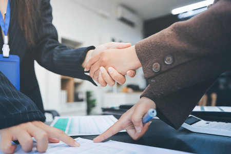 Business people shaking hands in office. Two business partners shaking hands after signing a contract in office.の写真素材