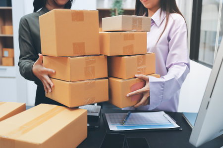 Portrait of Starting small businesses SME owners, two Asian woman check online orders Selling products working with boxs freelance work at home office, sme business online small medium enterpriseの写真素材