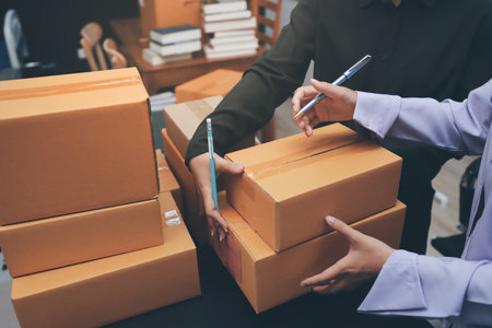 Portrait of Starting small businesses SME owners, two Asian woman check online orders Selling products working with boxs freelance work at home office, sme business online small medium enterpriseの写真素材