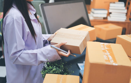 Portrait of Starting small businesses SME owners, two Asian woman check online orders Selling products working with boxs freelance work at home office, sme business online small medium enterpriseの写真素材