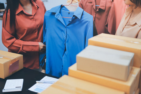 Portrait of Starting small businesses SME owners, two Asian woman check online orders Selling products working with boxes freelance work at home office, sme business online small medium enterpriseの写真素材