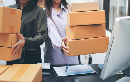 Portrait of Starting small businesses SME owners, two Asian woman check online orders Selling...