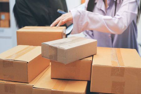 Portrait of Starting small businesses SME owners, two Asian woman check online orders Selling products working with boxs freelance work at home office, sme business online small medium enterpriseの写真素材