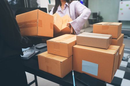 Portrait of Starting small businesses SME owners, two Asian woman check online orders Selling products working with boxs freelance work at home office, sme business online small medium enterpriseの写真素材