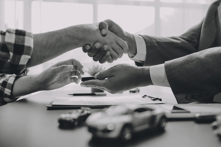 Car salesman gave the keys to the customers who signed the purchase contract legally, Successful completion of car sales, Purchase contract and key delivery.の写真素材
