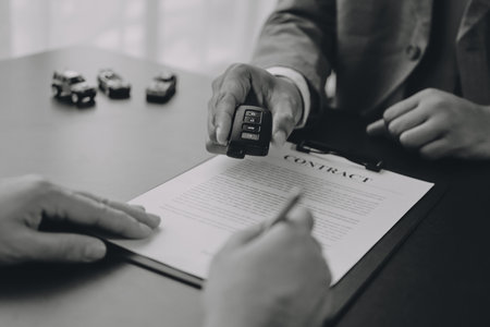 Car salesman gave the keys to the customers who signed the purchase contract legally, Successful completion of car sales, Purchase contract and key delivery.の写真素材