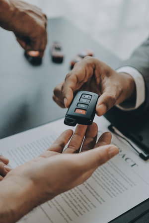 Car salesman gave the keys to the customers who signed the purchase contract legally, Successful completion of car sales, Purchase contract and key delivery.の写真素材