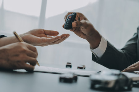 Car salesman gave the keys to the customers who signed the purchase contract legally, Successful completion of car sales, Purchase contract and key delivery.の写真素材