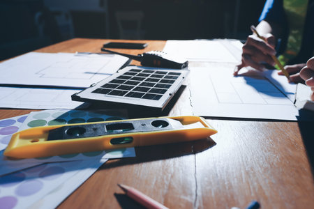 Closeup of team of industrial engineers meeting analyze machinery blueprints consult project on table in manufacturing factory. Working in manufacturing plant or production plant.の写真素材