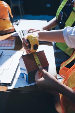 Closeup of team of industrial engineers meeting analyze machinery blueprints consult project on table in manufacturing factory. Working in manufacturing plant or production plant.の写真素材