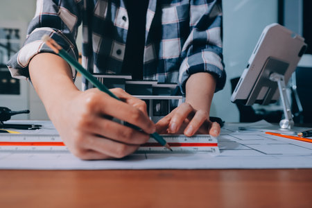 Construction and structure concept of engineer working drawing on blueprint meeting for project working with partner on model building and engineering tools in working site, construction concept.の写真素材