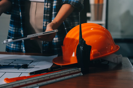 Construction and structure concept of engineer working drawing on blueprint meeting for project working with partner on model building and engineering tools in working site, construction concept.の写真素材