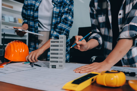 Construction and structure concept of engineer working drawing on blueprint meeting for project working with partner on model building and engineering tools in working site, construction concept.の写真素材
