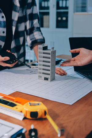 Construction and structure concept of engineer working drawing on blueprint meeting for project working with partner on model building and engineering tools in working site, construction concept.の写真素材