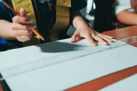 Closeup of team of industrial engineers meeting analyze machinery blueprints consult project on table in manufacturing factory. Working in manufacturing plant or production plant.の写真素材
