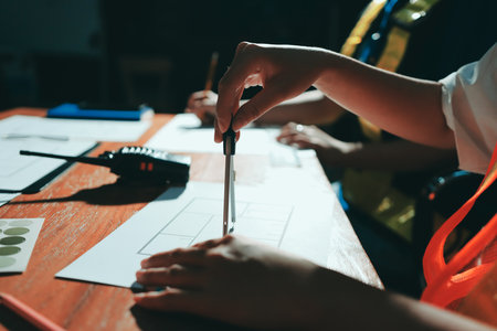 Closeup of team of industrial engineers meeting analyze machinery blueprints consult project on table in manufacturing factory. Working in manufacturing plant or production plant.の写真素材