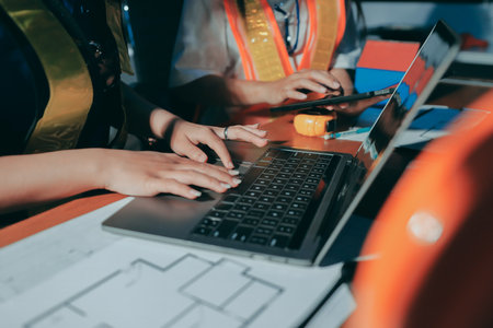 Closeup of team of industrial engineers meeting analyze machinery blueprints consult project on table in manufacturing factory. Working in manufacturing plant or production plant.の写真素材
