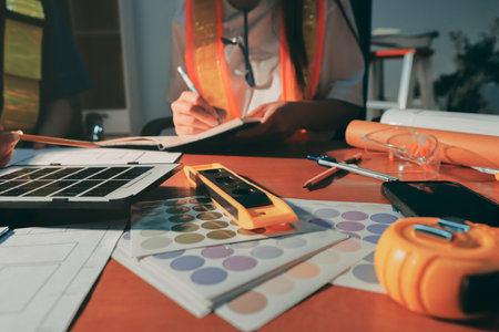 Closeup of team of industrial engineers meeting analyze machinery blueprints consult project on table in manufacturing factory. Working in manufacturing plant or production plant.の写真素材