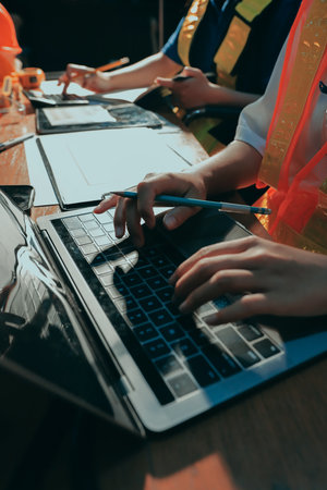 Closeup of team of industrial engineers meeting analyze machinery blueprints consult project on table in manufacturing factory. Working in manufacturing plant or production plant.の写真素材