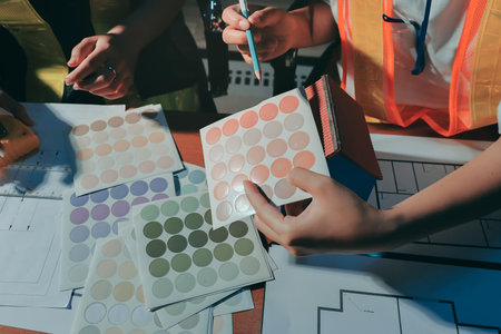 Closeup of team of industrial engineers meeting analyze machinery blueprints consult project on table in manufacturing factory. Working in manufacturing plant or production plant.の写真素材
