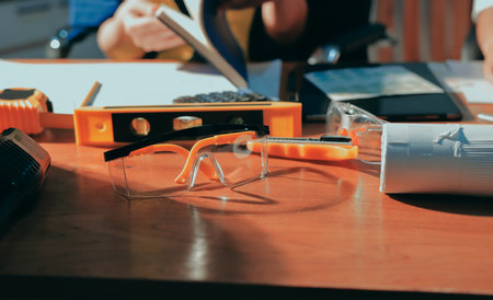 Closeup of team of industrial engineers meeting analyze machinery blueprints consult project on table in manufacturing factory. Working in manufacturing plant or production plant.の写真素材