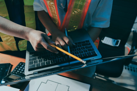 Closeup of team of industrial engineers meeting analyze machinery blueprints consult project on...