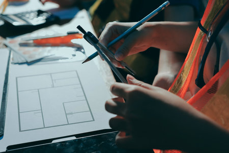 Closeup of team of industrial engineers meeting analyze machinery blueprints consult project on table in manufacturing factory. Working in manufacturing plant or production plant.の写真素材