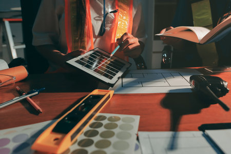 Closeup of team of industrial engineers meeting analyze machinery blueprints consult project on table in manufacturing factory. Working in manufacturing plant or production plant.の写真素材