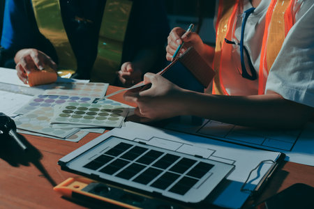 Closeup of team of industrial engineers meeting analyze machinery blueprints consult project on table in manufacturing factory. Working in manufacturing plant or production plant.の写真素材