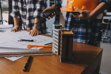 Construction and structure concept of engineer working drawing on blueprint meeting for project working with partner on model building and engineering tools in working site, construction concept.の写真素材