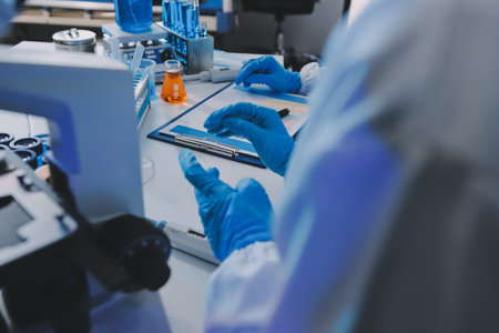 Collaboration, tablet or science with people in lab together for research or development. Innovation, tech and microscope with scientist team in clinical trial for planning or medical investigationの写真素材