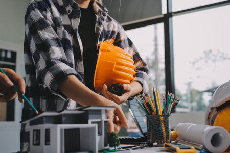 Construction and structure concept of engineer working drawing on blueprint meeting for project working with partner on model building and engineering tools in working site, construction concept.の写真素材