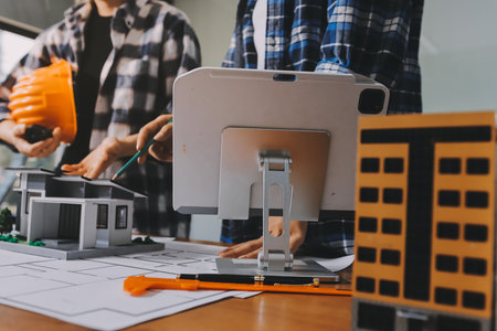 Construction and structure concept of engineer working drawing on blueprint meeting for project working with partner on model building and engineering tools in working site, construction concept.の写真素材