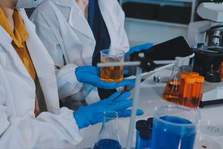 Collaboration, tablet or science with people in lab together for research or development. Innovation, tech and microscope with scientist team in clinical trial for planning or medical investigationの写真素材